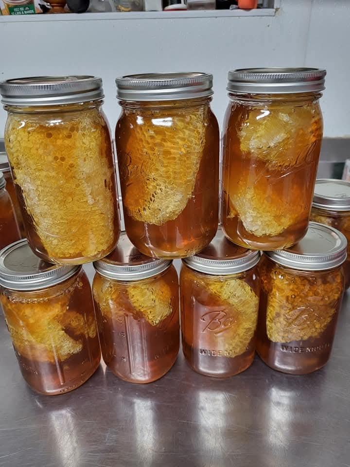 Jars of Happy Bee honey with honeycomb